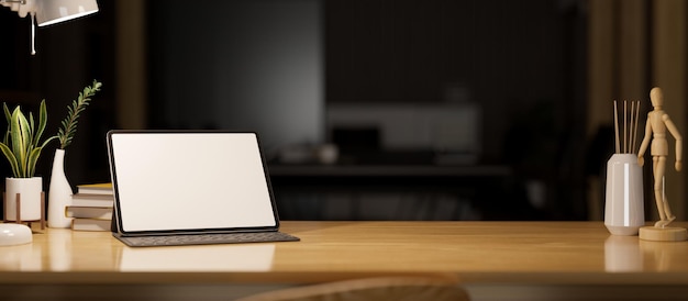 Maquette de tablette numérique et espace de copie sur une table en bois au-dessus du bureau sombre en arrière-plan