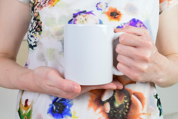 Maquette de tasse à café de 11 oz tenue par une femme