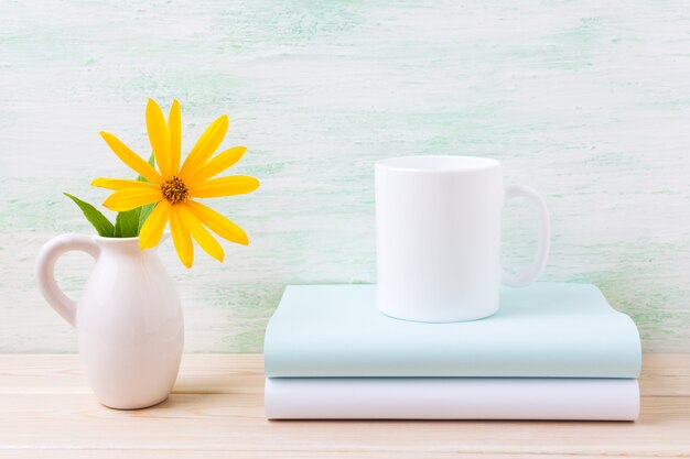 Photo maquette de tasse à café blanche avec rosinweed jaune d'or dans le pichet