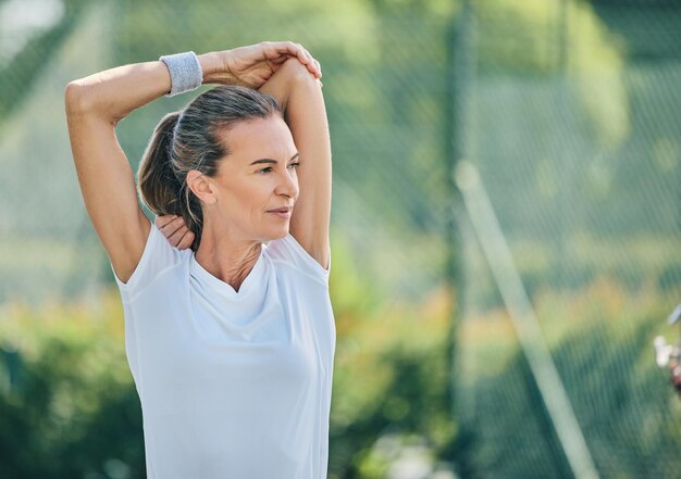 Maquette de tennis et étirements avec une femme sportive sur un terrain pour un échauffement avant son match de compétition Fitness et entraînement sportifs avec une athlète féminine senior se préparant pour un match d'entraînement