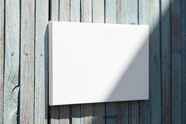 Maquette en toile tendue blanche avec ombre au soleil sur un mur en bois bleu