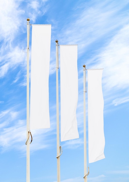 Maquette de trois drapeaux d'entreprise blancs contre le ciel bleu