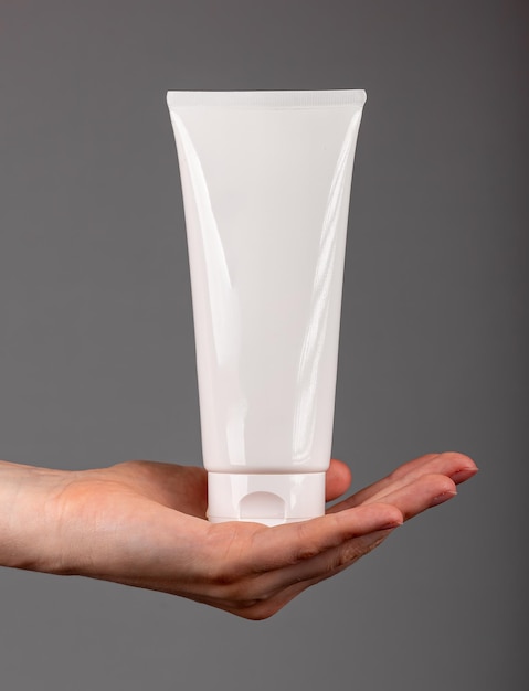 Maquette de tube de crème beauté vierge produit cosmétique hydratant maquette ion main paume isolé sur blanc