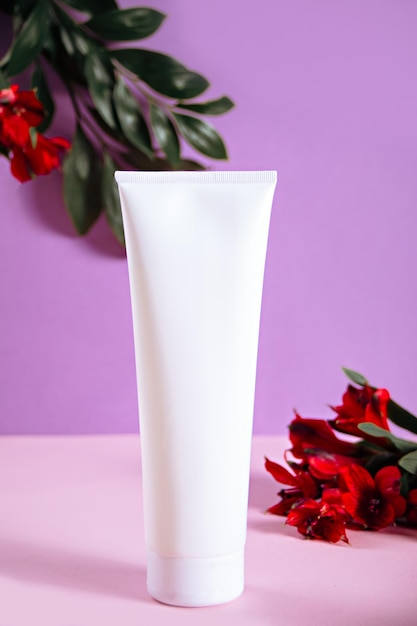 Maquette vierge bouteille beauté cosmétique soins de la peau produit biologique pour la routine de bain avec des fleurs sur fond violet Placez votre conception