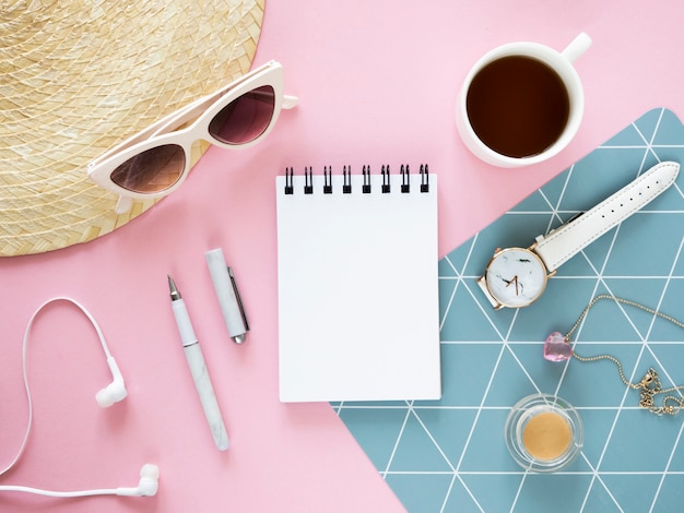 Maquette de vue de dessus de bureau de femme à la mode. Cahier ouvert, chapeau de paille et lunettes de soleil. Copiez l'espace pour les notes sur une feuille de papier.