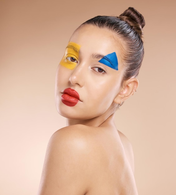 Maquillage de beauté et clown par femme en studio pour l'art amusant et l'expression créative sur fond marron avec maquette Portrait de visage et produit cosmétique pigmenté avec esthétique de cirque modèle fille