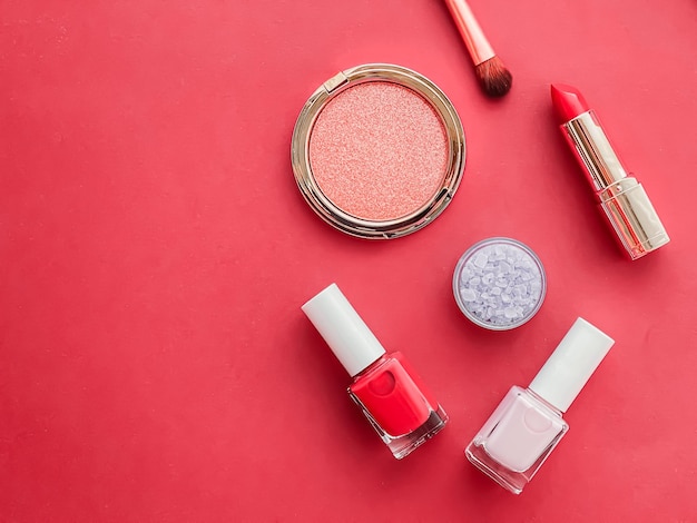 Maquillage de beauté et cosmétiques flatlay design avec des produits cosmétiques et des outils de maquillage sur fond corail concept de style girly et féminin