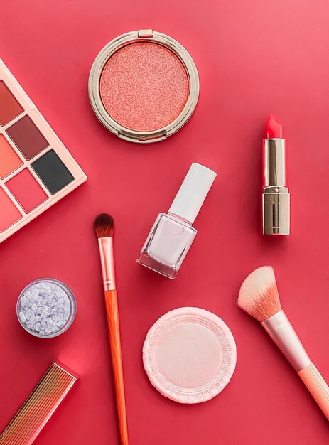 Maquillage de beauté et cosmétiques flatlay design avec des produits cosmétiques et des outils de maquillage sur fond corail concept de style girly et féminin