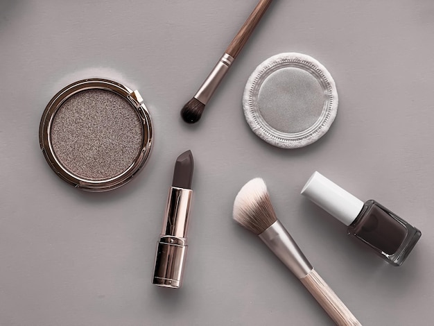 Maquillage de beauté et cosmétiques flatlay design avec des produits cosmétiques et des outils de maquillage sur fond gris style girly et féminin