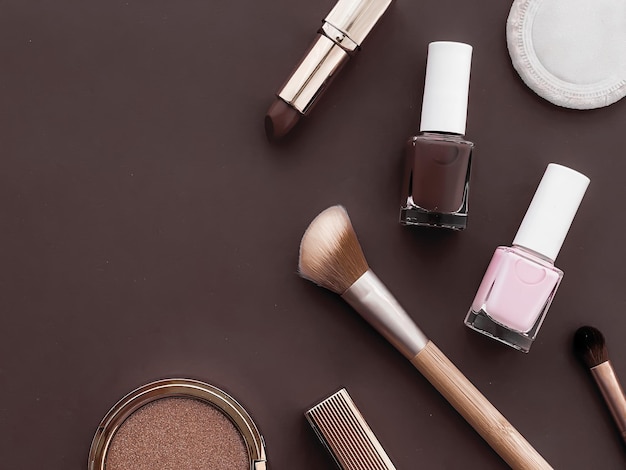 Maquillage de beauté et cosmétiques flatlay design avec des produits cosmétiques et des outils de maquillage sur fond marron style girly et féminin