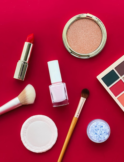 Maquillage de beauté et cosmétiques flatlay design avec des produits cosmétiques et des outils de maquillage sur fond rouge concept de style girly et féminin