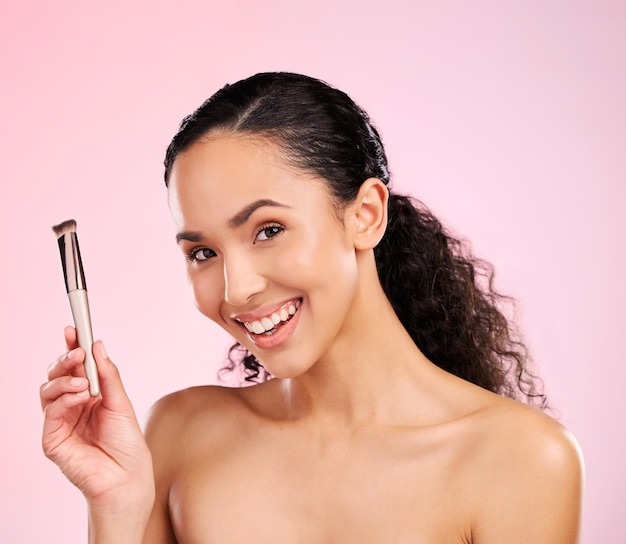 Maquillage de beauté et pinceau avec portrait de femme en studio pour les cosmétiques de fondation et le soin du visage la santé et les soins personnels avec le visage du modèle sur fond rose pour la dermatologie lueur et produit