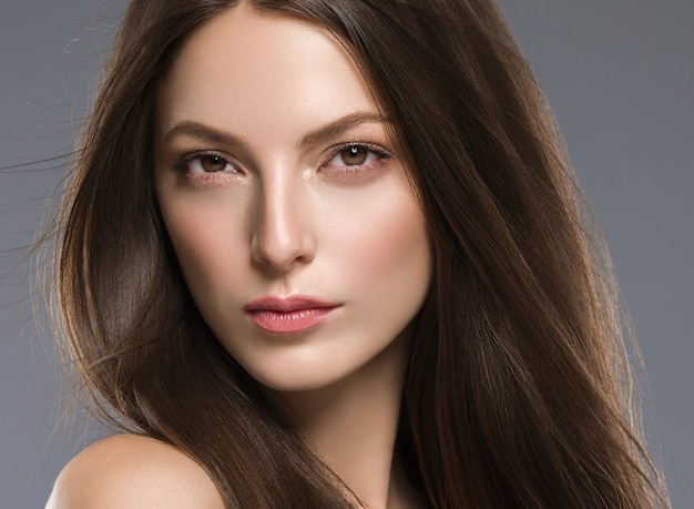 Maquillage de peau belle femme cheveux longs cheveux brune. Prise de vue en studio.