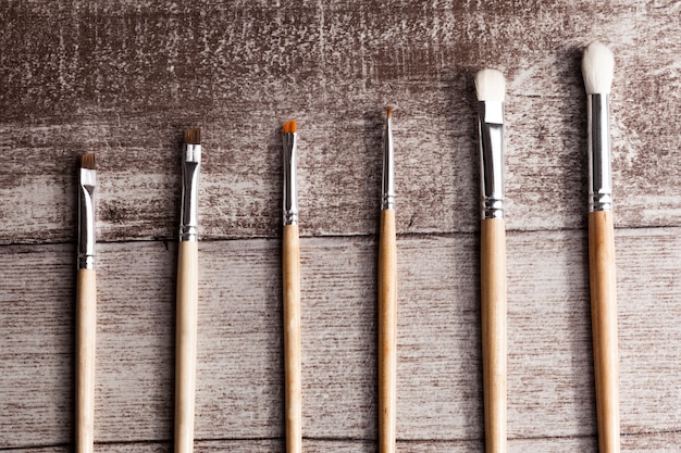 Maquillage des pinceaux sur fond de bois en photo de studio. Soins du visage et cosmétiques