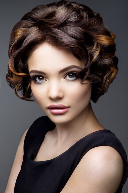 Maquillage. Portrait glamour du modèle belle femme avec du maquillage frais et une coiffure ondulée romantique.