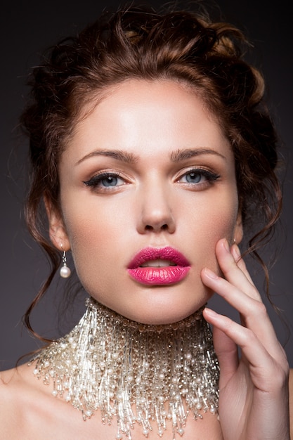 Maquillage. Portrait glamour du modèle belle femme avec du maquillage frais et une coiffure ondulée romantique.