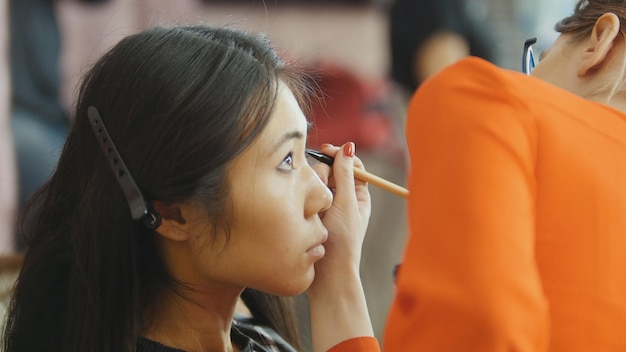 Maquillage pour modèle asiatique aux cheveux noirs avant la séance photo