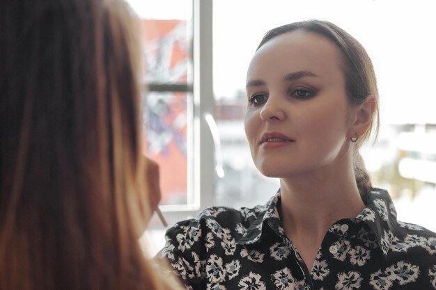 Maquilleuse maquilleuse jolie jeune femme dans un salon de beauté