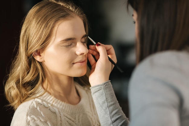 Maquilleuse travaille avec un modèle dans un studio de beauté Commence à travailler Modèle sans maquillage Beau maquillage artst