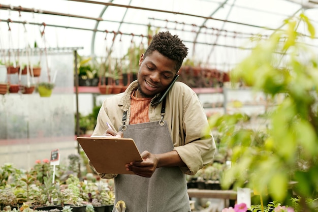 Marchande de fleurs prenant une commande par téléphone portable