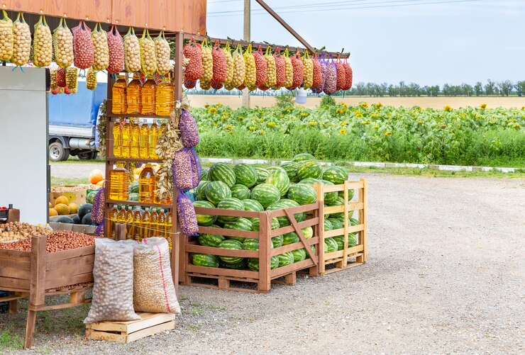 Photo marché d'agriculteurs au bord de la route vendant des denrées alimentaires écologiques sur le fond d'un champ de tournesols
