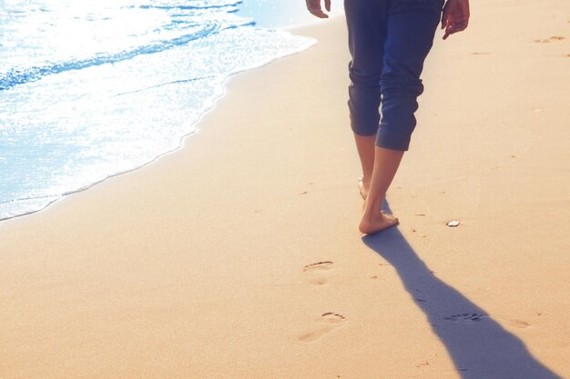 Marcher sur la plage en laissant des empreintes dans le sable