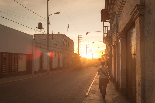 Marcher seul en ville au coucher du soleil en contre-jour