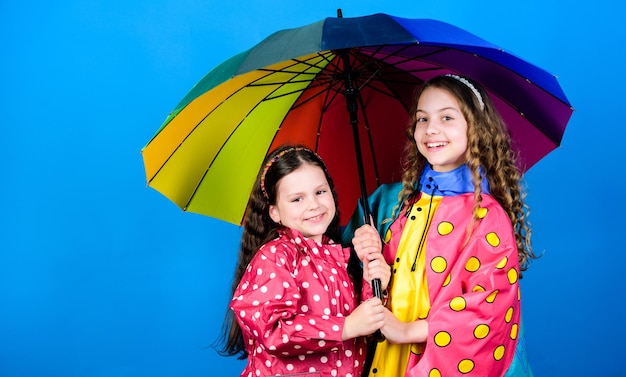 Marcher sous un parapluie Enfants filles amis heureux sous un parapluie Temps pluvieux avec des vêtements appropriés Enfance heureuse Parapluie lumineux Il est plus facile d'être heureux ensemble Soyez arc-en-ciel dans le nuage de quelqu'un