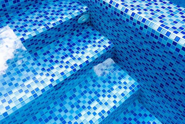 Marches dans la piscine avec mosaïque de carreaux de céramique bleue Détendez-vous dans l'arrière-cour d'une maison de campagne