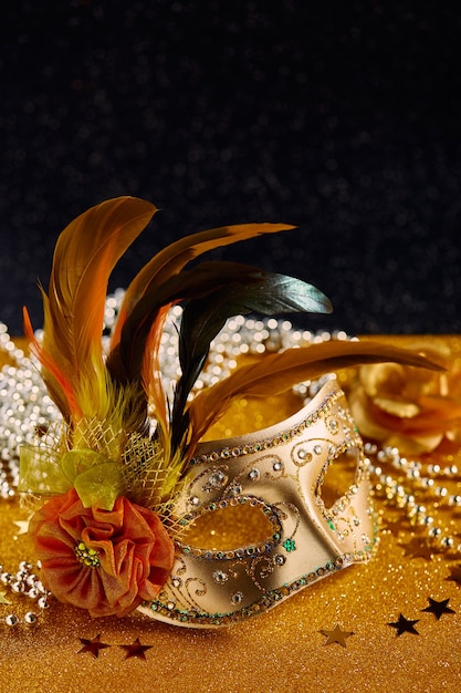 Mardi gras coloré festif ou masque de carnaval avec des plumes et des perles sur fond doré masques vénitiens carte de voeux invitation fête carnaval vénitien célébration concept