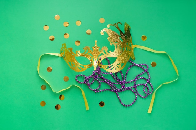 Mardi gras, concept de carnaval. Masque en or avec perles et confettis