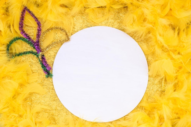 Mardi Gras Mockup Panneau rond vide en bois avec espace de copie sur boa de plumes dorées