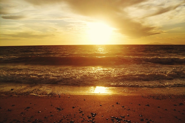 Photo la marée sur la plage au coucher du soleil
