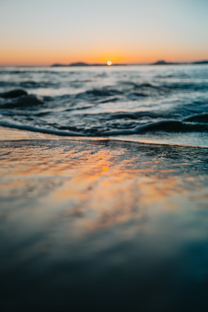 Photo une marée sur le sable de la plage lors d'un coucher de soleil au printemps avec des tons colorés