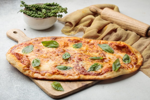 Margherita Pizza servie dans une planche à découper isolée sur la vue de dessus de table de la nourriture arabe