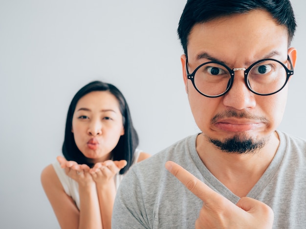 Un mari asiatique en colère et agacé avec une femme heureuse et têtue