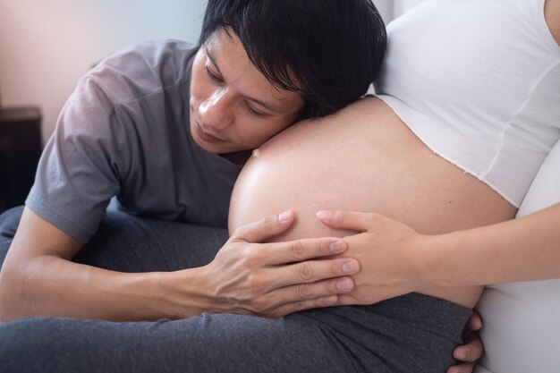 Le mari était heureux d'entendre les enfants dans le ventre de sa femme la femme peut tomber enceinte 5 mois sont ravis de vous voir bébé