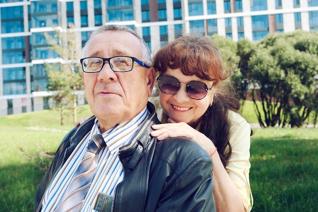 Mari et femme âgés lors d'une promenade se tenant la main dans un parc de la ville profitant d'une journée d'été