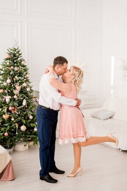 Mari et femme avec arbre de Noël, le couple s'embrasse