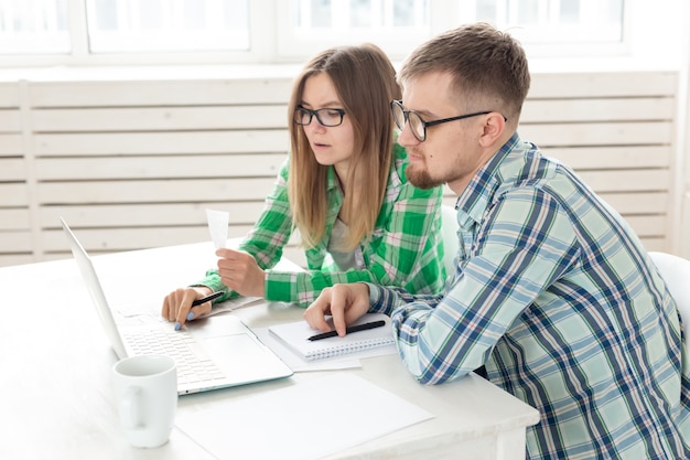 Le mari et la femme discutent du montant du chèque pour le paiement de l'appartement et le comparent aux tarifs