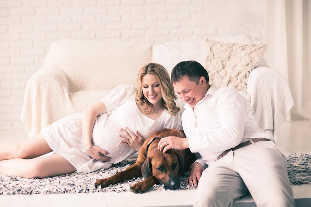 Mari femme enceinte et chien reposant sur le lit avec le bedro