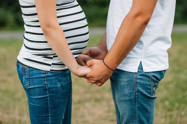 mari et femme enceinte se tenant la main