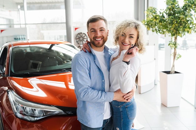 Mari et femme joyeux dans un concessionnaire automobile