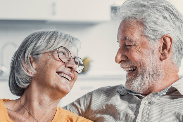 Photo un mari et une femme mûrs heureux s'assoient et se reposent sur le canapé à la maison en s'étreignant et en se caressant, en montrant de l'affection, en souriant, en étant âgés, en s'aimant, en se relaxant sur le canappé, en samusant, en profitant d'un week-end familial tendre et romantique.