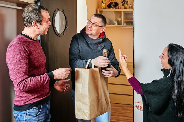 Le mari et la femme offrent un cadeau à leur ami.