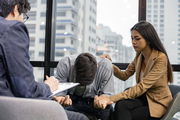 Mari et femme parlent, aident et soutiennent par un psychiatre. Concept de santé mentale, couple de jeunes problématiques parlant avec un conseiller d'orientation.