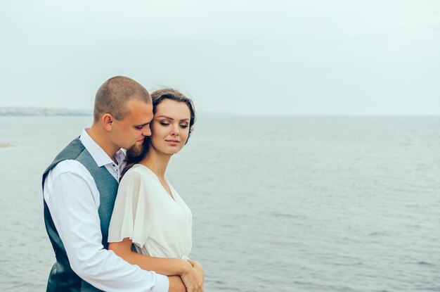 mari et femme s'embrassant au bord de la mer