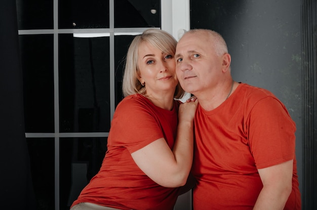 mari et femme en t-shirts orange s'embrassent et s'embrassent