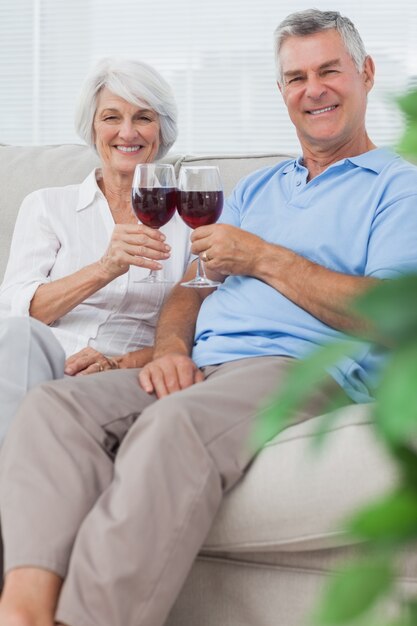 Mari et femme tinter leurs verres de vin rouge