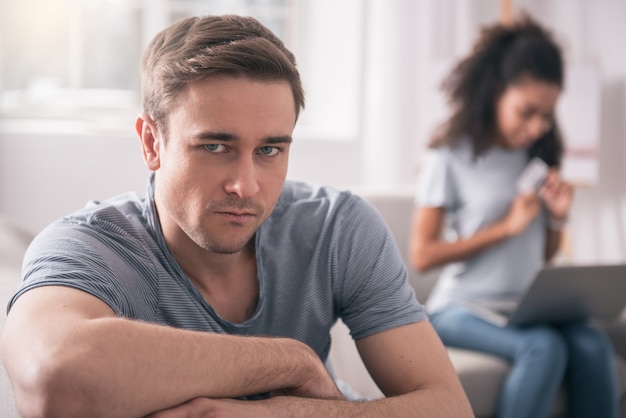 Mari malheureux. Homme triste et sans joie vous regarde tout en étant mécontent de sa dépendance au shopping